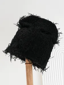 Detailed view of a black distressed knit balaclava hat with unique fringe texture