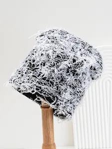 Detailed view of a distressed black and white fuzzy knit beanie hat on a wooden stand