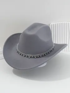 Dettaglio ravvicinato di un cappello da cowboy grigio con eleganti frange in strass.