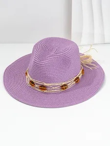 Detail view of a purple Panama straw hat with amber bead decoration