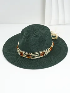 Close-up of dark green Panama straw hat with amber gem decorative band detail.