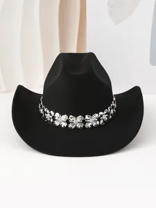 Detalle de sombrero de vaquero negro con banda decorativa de trébol de plata.