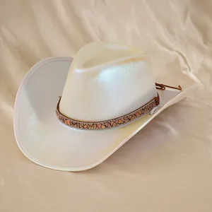 Dettaglio di un cappello da cowboy bianco iridescente con fascia decorativa luccicante