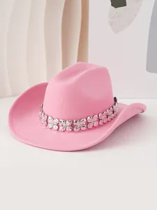 Detalle de sombrero de vaquero de fieltro rosa con elegante banda metálica de trébol