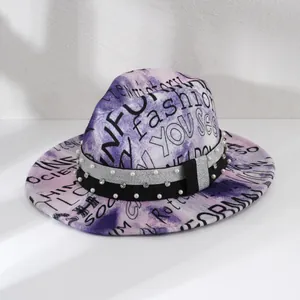 Detail of tie-dye fedora hat featuring letter prints and a pearl rhinestone band.