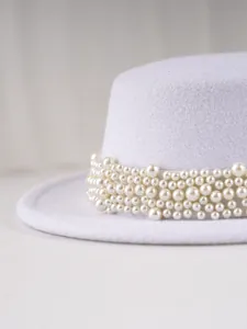 Vue détaillée d'un élégant chapeau en feutre de laine blanc avec décoration de perles