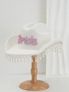 Close-up detail of white wool cowboy hat with pink pearl Bride text and pearl fringe
