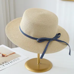 Detailed view of high-quality raffia straw sun hat with stylish blue ribbon bow decoration