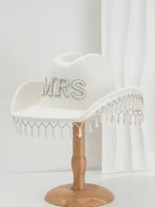 Close-up detail of white wool bridal cowboy hat with MRS rhinestones and pearl tassels