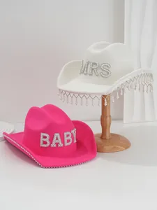 Close-up of pink and white felt cowboy hats with rhinestone letters and pearl fringe