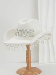 Close-up of white wool cowboy hat with rhinestone 'BRIDE' and pearl fringe decor