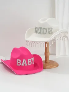 Detailed view of rhinestone BRIDE and BABY lettering on elegant felt cowboy hats