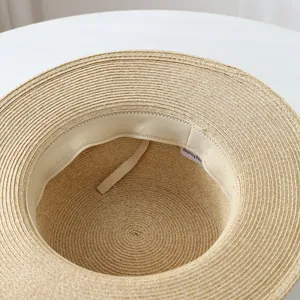 Detailed view of women's raffia straw sun hat with inner sweatband and label.