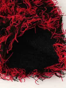 Detailansicht der rot-schwarzen, zotteligen Strickmütze mit Quastentextur