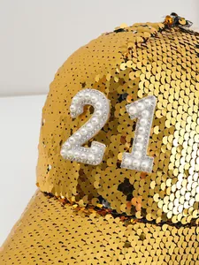 Detailed macro view of gold sequined baseball cap with pearl and rhinestone number 21 design