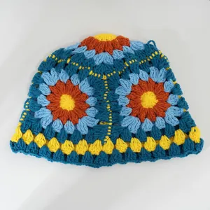 Dettaglio cappello a secchiello all'uncinetto con vivaci motivi floreali patchwork.