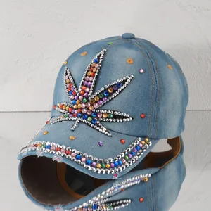 Detailaufnahme einer blauen Denim-Basecap mit buntem Strass-Blattmuster-Verzierung