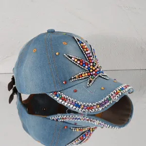 Nahaufnahme einer blauen Denim-Baseballkappe mit buntem Blatt-Patch aus Strasssteinen
