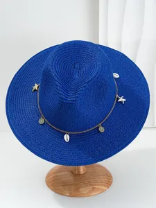 Detailweergave van een blauwe Panama-strohoed met decoratieve schelpen en sterren