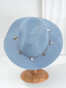 Detailweergave van lichtblauwe Panama strohoed met zeester en schelphangers voor het strand