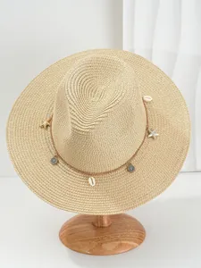 Detailweergave van strooien Panama-hoed met schelp- en zeesteraccessoires op standaard