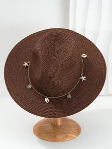 Detailweergave van bruine Panama-strohoed met schelp- en zeesterkettingaccessoires
