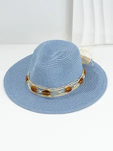 Detail view of blue woven straw hat with amber gemstone and netted rope band.
