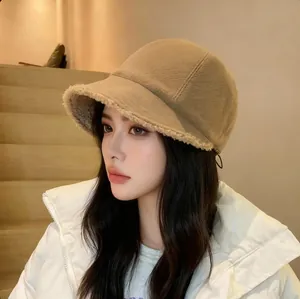 Detail view of a warm khaki fleece-lined bucket hat worn by a model in an indoor setting