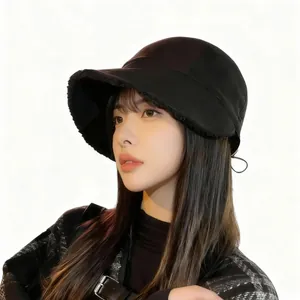 Close-up of stylish black fleece-lined bucket hat worn by model for autumn winter