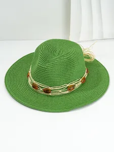 Detailed view of a green Panama straw hat with amber gemstone bead band decoration.