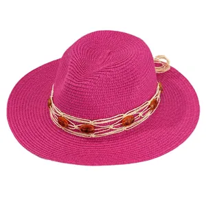 Vibrant magenta Panama straw beach hat featuring woven amber gemstone decorations
