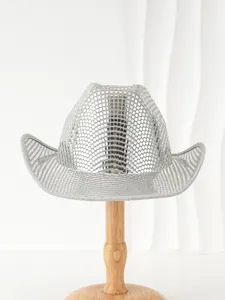 Dettaglio di un cappello da cowboy con paillettes disco argento su base di legno