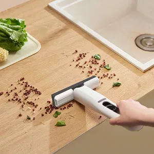 Close-up detail of a portable mini sponge mop cleaning waste on a wooden kitchen countertop