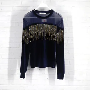 Detail of navy blue velvet top with mesh shoulders and shimmering sequin fringe decoration