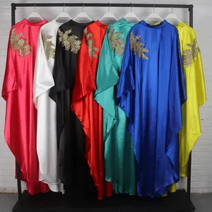 Colorful African style kaftan dresses with golden floral appliques displayed on a garment rack