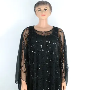 Detalle de vestido largo africano en malla negra con patrones de lentejuelas brillantes