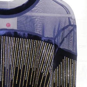 Detailed view of navy blue velvet top with mesh panel and vertical gold rhinestone accents