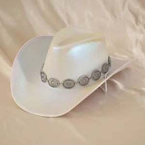 Dettaglio di un cappello da cowboy iridescente con decorazioni concho floreali