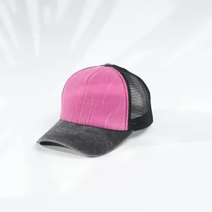 Detailansicht eines stylischen rosa-schwarzen Mesh-Trucker-Huts mit Denim-Krempe.