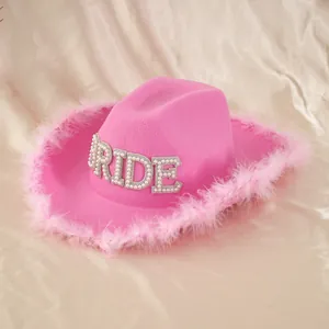 Detailed view of pearl and rhinestone 'BRIDE' lettering on pink feather cowboy hat