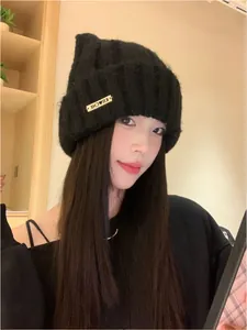 Close-up detail of a stylish black Korean-style knitted cat ear beanie worn by a model.