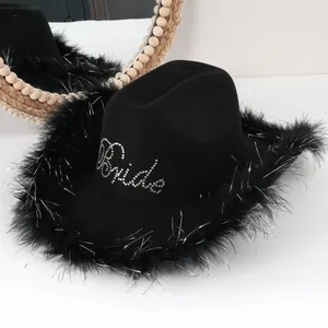Dettaglio di un cappello da cowboy nero con scritta Bride in strass e bordo in piume per feste.