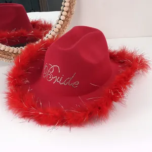 Primo piano del cappello da cowboy rosso con piume e scritta Bride in strass