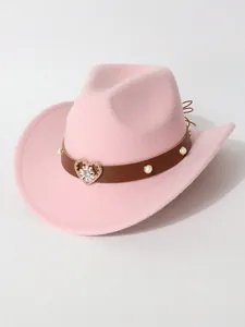 Detail of pink western cowboy hat featuring heart rhinestone ornament and pearl studs.