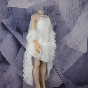 Detailed side view of white mesh African dress with elegant feather trimming.