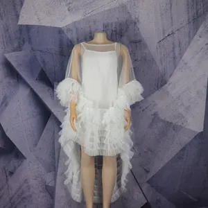Detail view of white mesh African dress with layered feather ruffles and camisole.