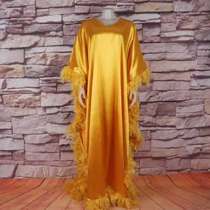 Gelbes afrikanisches Kaftankleid mit luxuriösem Federbesatz und Fledermausärmeln im Detail