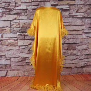 Detaillierte Rückansicht des luxuriösen gelben afrikanischen Kaftans mit Federbesatz.