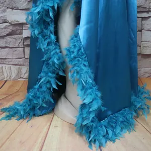 Detailansicht der blauen Satinstola mit luxuriösem Federbesatz und hohem Schlitzdesign.