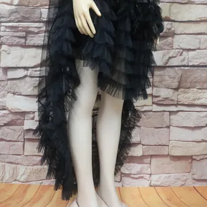 Detailed view of black ruffled tulle dress with feather trim and asymmetric hemline